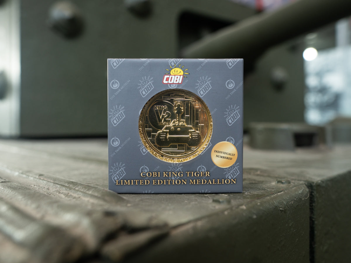 A gold medallion coin showcasing an outline of the King Tiger V2 Tank. The Medallion is in a grey box with the COBI & The Tank Museum Logo