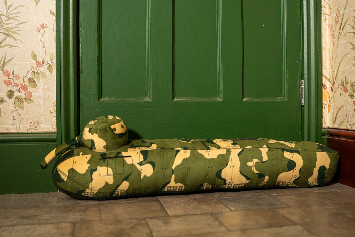 A long draught excluder shaped as a TOG II tank with a camouflage print.