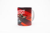 A white ceramic mug featuring a red and black graphic design with the word 'Tankfest' in bold white letters, an illustration of a tank, and a small vehicle image near the bottom, shown on a plain white background.